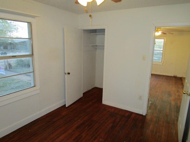 unfurnished bedroom featuring ceiling fan, a closet, and dark hardwood / wood-style floors