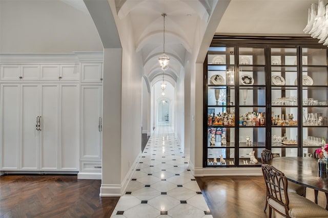 hall featuring a notable chandelier and dark parquet floors