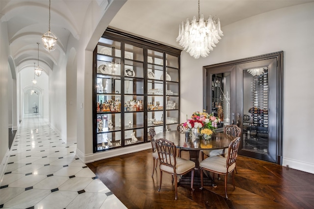 dining room featuring a chandelier and parquet floors