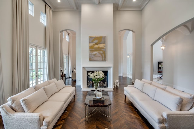 living room with beam ceiling, french doors, a towering ceiling, and dark parquet floors