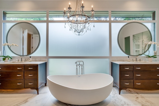 bathroom featuring a washtub, an inviting chandelier, and vanity