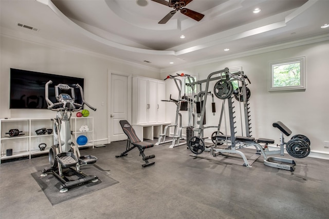 workout area with ceiling fan, ornamental molding, and a tray ceiling