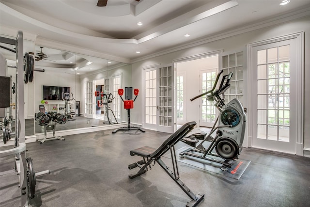 exercise room with ceiling fan, a tray ceiling, and ornamental molding