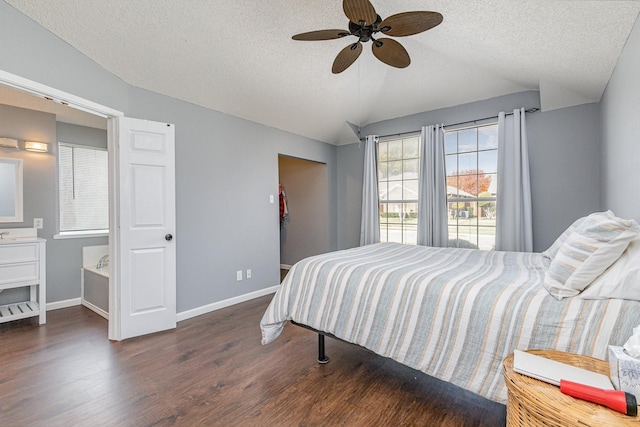 bedroom with ceiling fan, dark wood-type flooring, lofted ceiling, and a textured ceiling