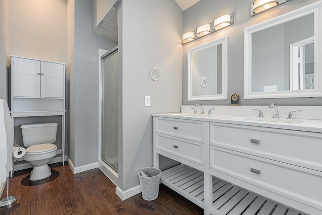 bathroom featuring wood-type flooring, walk in shower, vanity, and toilet