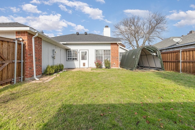 rear view of property featuring a lawn