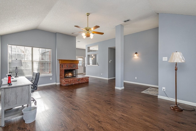 office area featuring vaulted ceiling, ceiling fan, dark hardwood / wood-style floors, a fireplace, and a textured ceiling