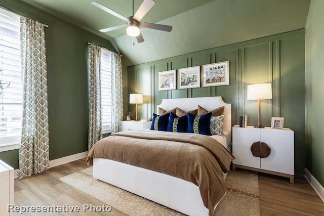 bedroom with ceiling fan, vaulted ceiling, and wood-type flooring