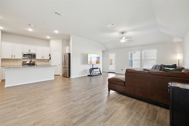 living room featuring lofted ceiling and ceiling fan