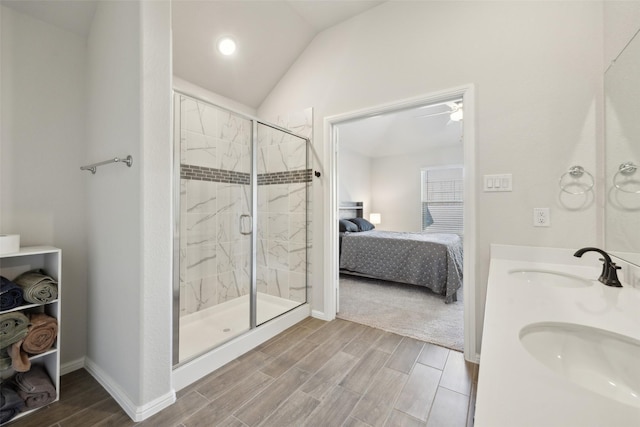 bathroom featuring vaulted ceiling, a shower with shower door, and sink