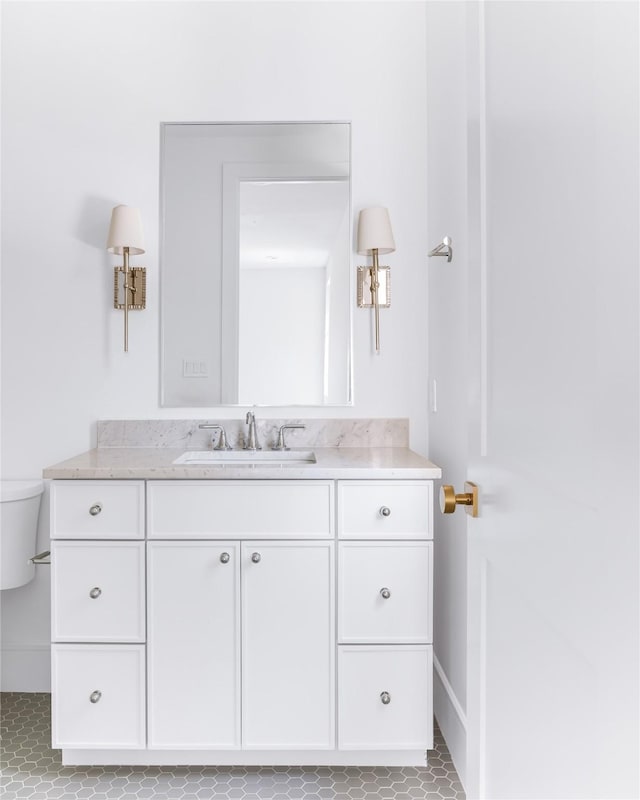 bathroom with toilet, vanity, and tile patterned flooring