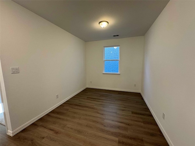 unfurnished room with dark wood-type flooring