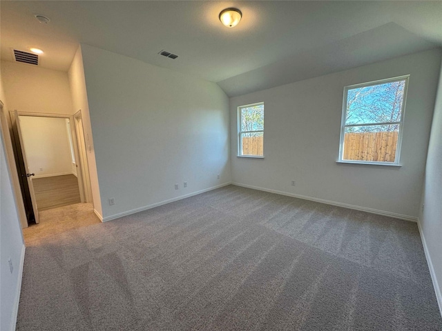 spare room featuring lofted ceiling and carpet flooring