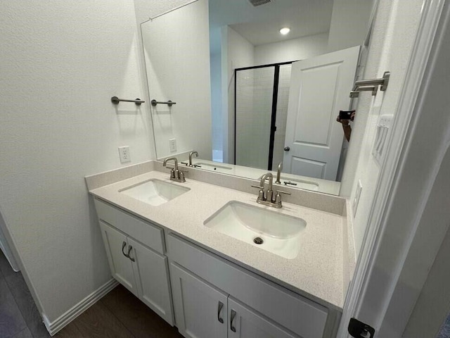 bathroom featuring hardwood / wood-style floors, an enclosed shower, and vanity