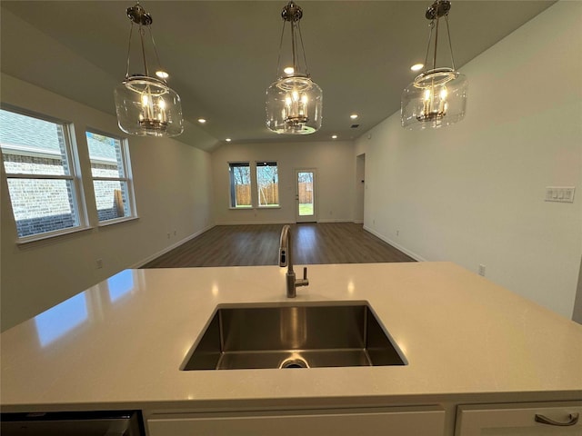 kitchen featuring dishwasher, vaulted ceiling, pendant lighting, and sink