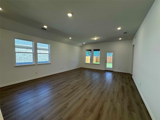 spare room with lofted ceiling and dark hardwood / wood-style flooring