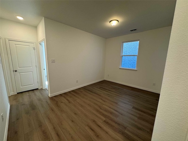 spare room featuring dark wood-type flooring