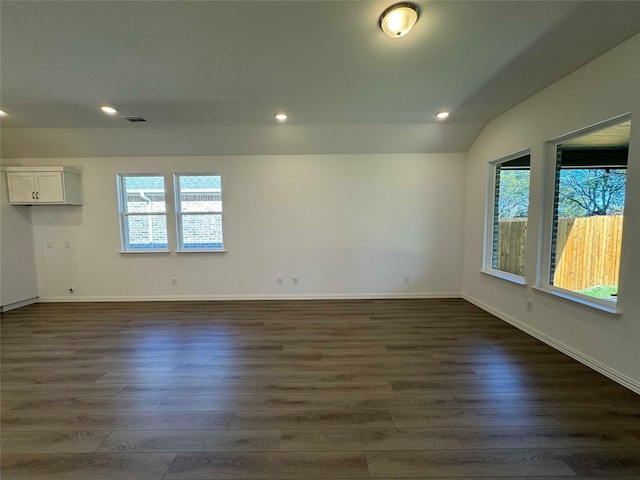 unfurnished room with vaulted ceiling and dark hardwood / wood-style flooring