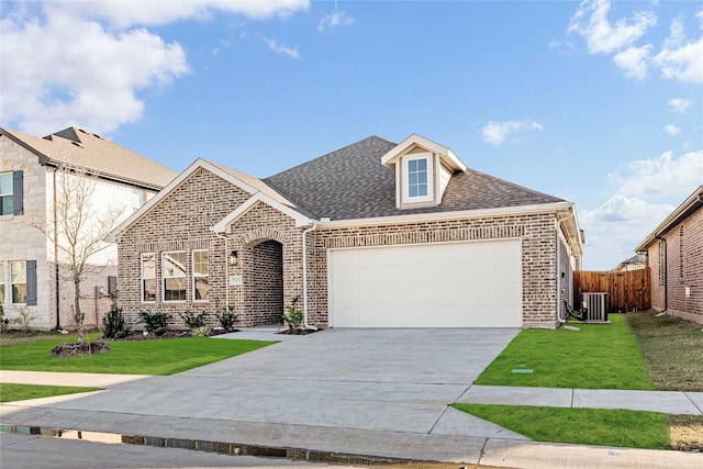 view of front of home featuring a front yard, a garage, and central air condition unit