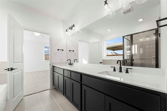 bathroom featuring a shower with door, tile patterned flooring, a wealth of natural light, and vanity