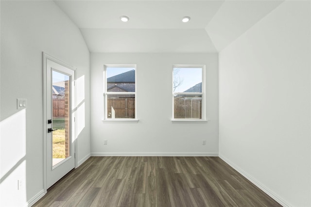 empty room featuring dark wood-type flooring and lofted ceiling