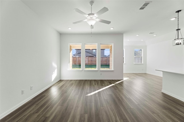 unfurnished living room with dark wood-type flooring and ceiling fan