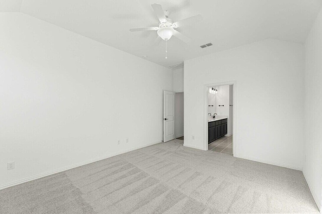 unfurnished bedroom featuring sink, ensuite bathroom, light carpet, and ceiling fan