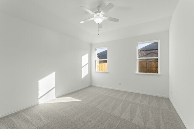 spare room with ceiling fan and light carpet