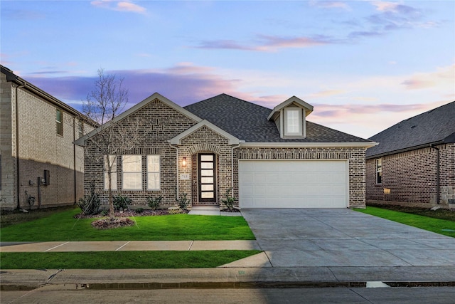 view of front of home with a yard and a garage