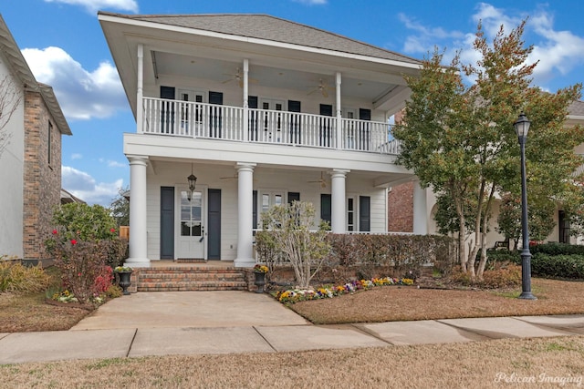 view of front of house featuring ceiling fan, covered porch, and a balcony