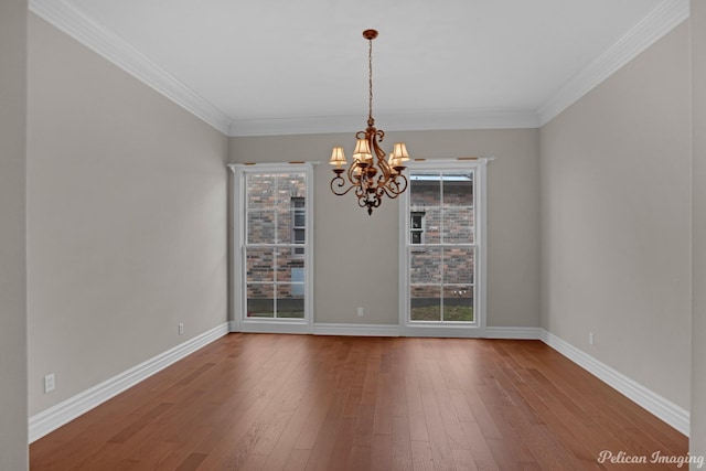 unfurnished dining area with an inviting chandelier, hardwood / wood-style floors, and crown molding