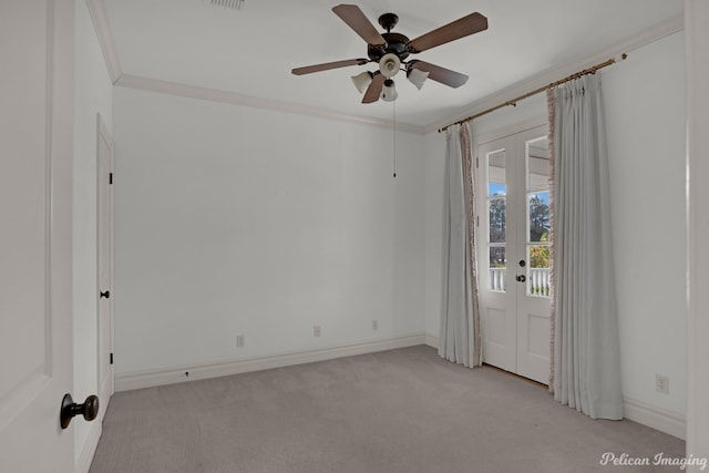 carpeted spare room with ornamental molding, ceiling fan, and french doors