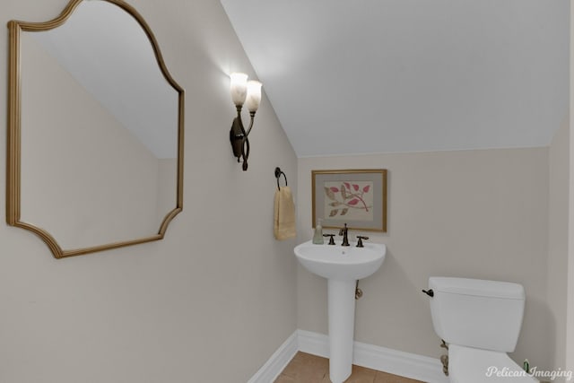 bathroom featuring lofted ceiling, tile patterned floors, and toilet