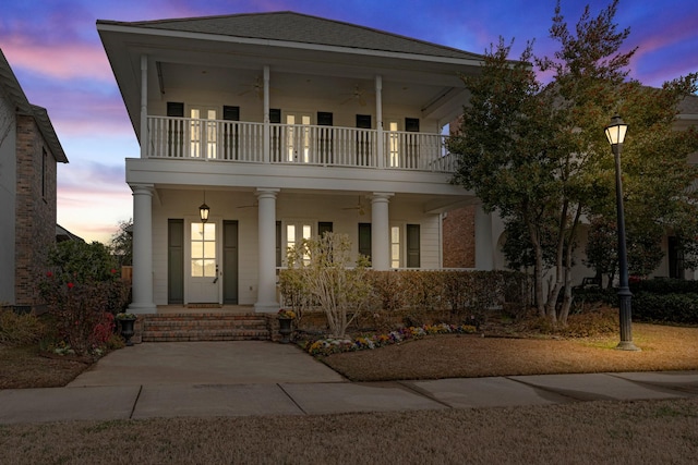 view of front of home with a porch, a balcony, and ceiling fan