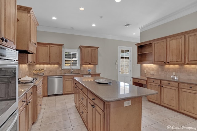 kitchen with stainless steel appliances, a center island, ornamental molding, sink, and light tile patterned flooring