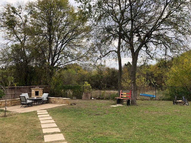 view of yard with a patio area and an outdoor stone fireplace