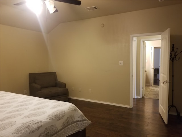 bedroom with ceiling fan, dark wood-type flooring, and vaulted ceiling