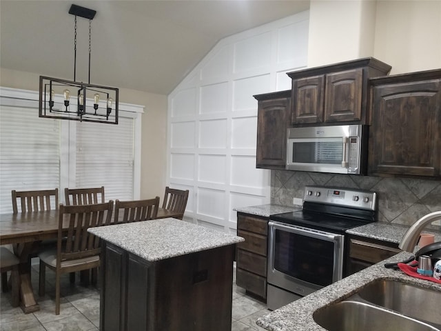 kitchen featuring stainless steel appliances, sink, vaulted ceiling, and dark brown cabinetry