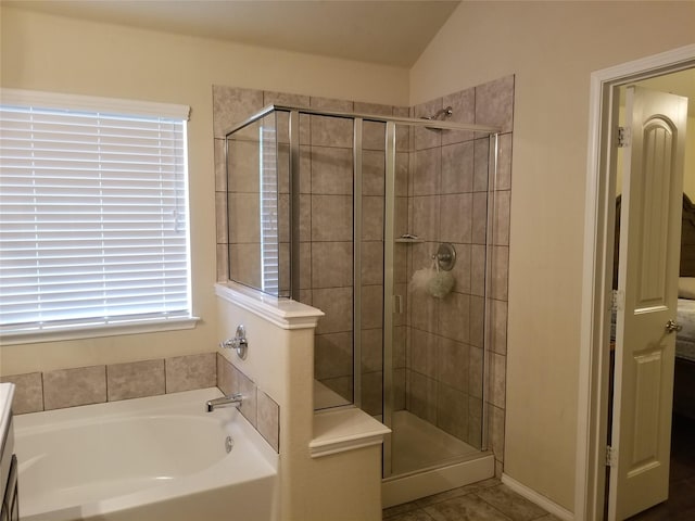 bathroom featuring tile patterned floors, lofted ceiling, vanity, and shower with separate bathtub