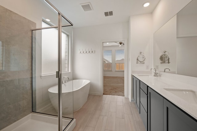 bathroom with vanity, ceiling fan, and plus walk in shower