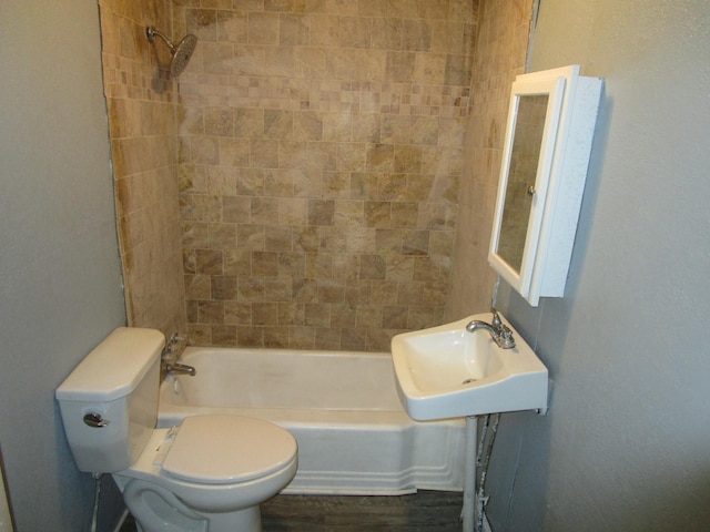 full bathroom with toilet, tiled shower / bath, and sink