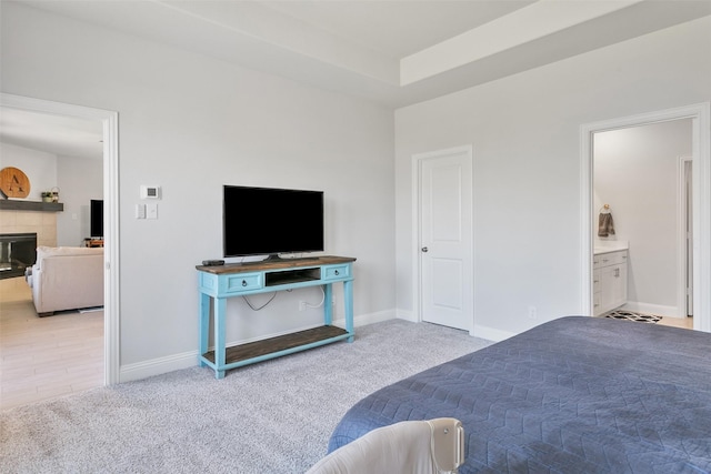 carpeted bedroom featuring a fireplace and ensuite bathroom