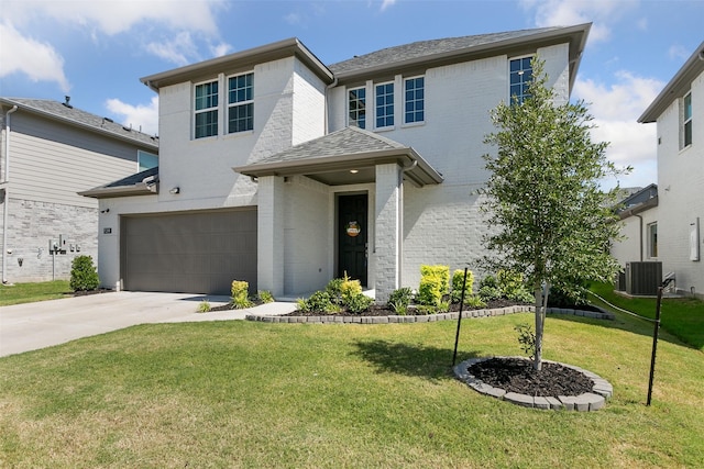 view of front of home with a garage, a front yard, and central AC unit