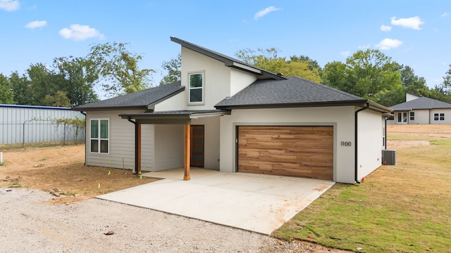 view of front of property featuring central AC and a garage