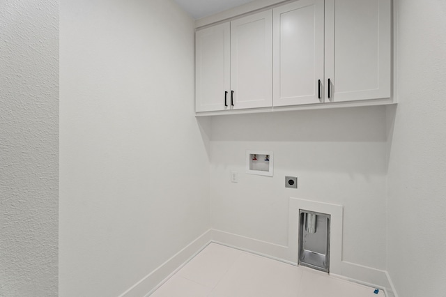 clothes washing area featuring electric dryer hookup, hookup for a washing machine, cabinets, and light tile patterned floors