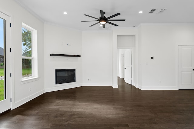 unfurnished living room with dark hardwood / wood-style flooring, crown molding, and a healthy amount of sunlight