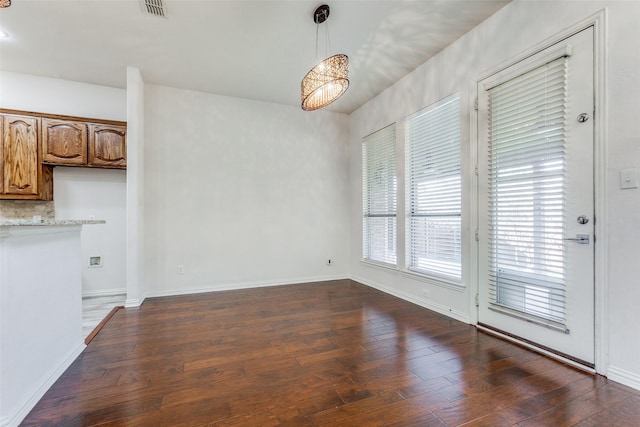 unfurnished dining area with dark hardwood / wood-style flooring