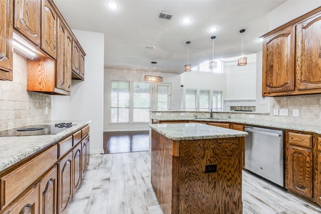 kitchen with light wood-type flooring, tasteful backsplash, stainless steel dishwasher, a kitchen island, and black electric stovetop