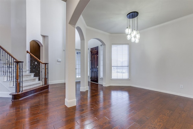 entrance foyer with a notable chandelier, ornamental molding, and dark hardwood / wood-style flooring