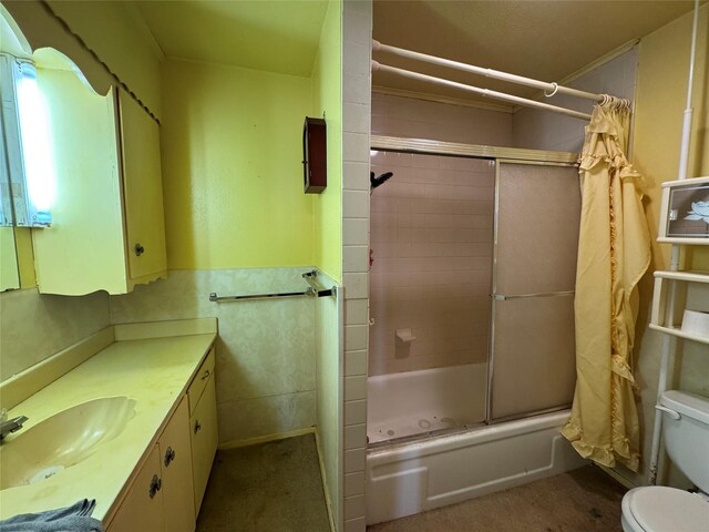 full bathroom featuring toilet, vanity, and bath / shower combo with glass door